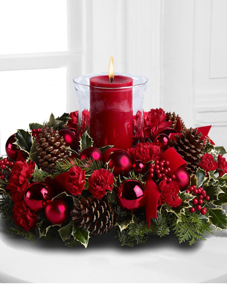 Christmas by Candlelight Standard Picture the joy of Christmas, and the faces of family and friends radiant in the warm glow of candlelight around your holiday table. Then bring that charming scene to life with this lovely centerpiece featuring a crystal hurricane cradling a red pillar candle. Simply beautiful!
DELIVERY: Every order is hand-delivered direct to the recipient. These items will be delivered by us locally, or a qualified retail local florist.