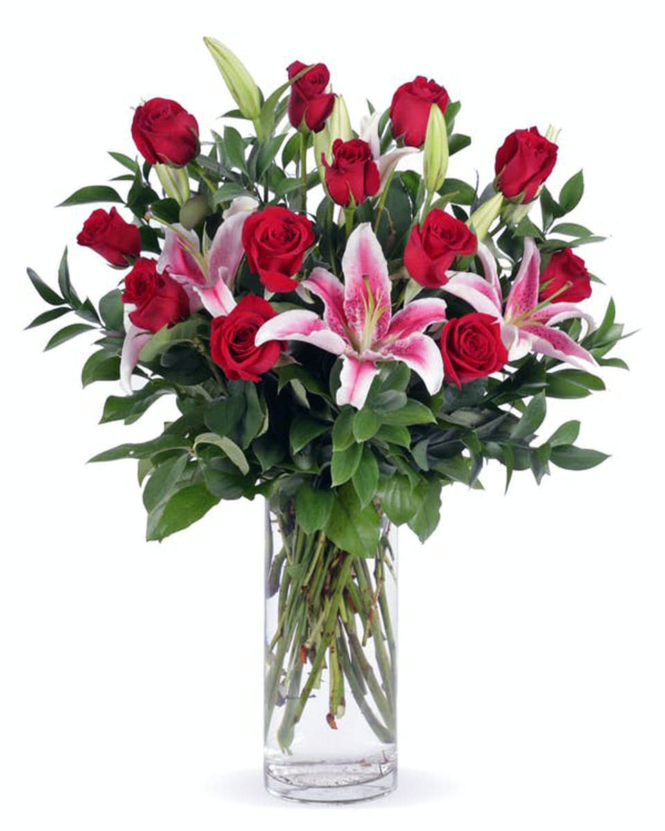 A Rose Parade Standard-12 Roses and Stargazers This romantic arrangement of stargazer lilies, red roses and garden greens will help to celebrate your occasion with style. Made with #1 Grade ,Ecuadorian, Explorer Red Roses,  and California grown lilies. The colors and fragrance make a memorable gift.
DELIVERY: Every order is hand-delivered direct to the recipient. These items will be delivered by us locally, or a qualified retail local florist.