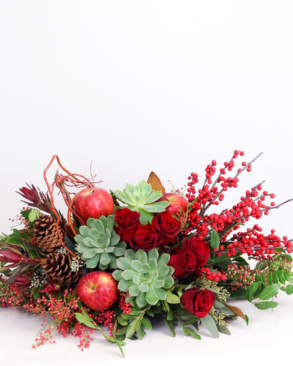 Winter Succulent Garden Standard Premium red roses, holiday berries, whimsical branches, apples, succulents and loads of premium seasonal greens and accents make this a jaw-dropping centerpiece for any table.
Approximately 25 inches wide and 8 inches tall.
DELIVERY: Every order is hand-delivered direct to the recipient. This item is only deliverable to local areas serviced by Allen’s Flower Market Stores. 