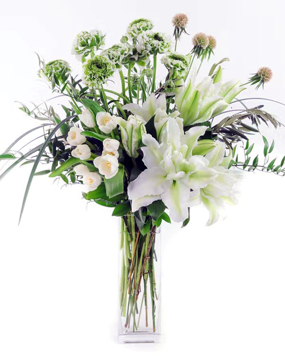 Elegance in White Deluxe Locally-grown ranunculus and locally-grown rose lilies are combined with lush locally-grown greens and other textural elements in this jaw-dropper available for an extremely limited time.