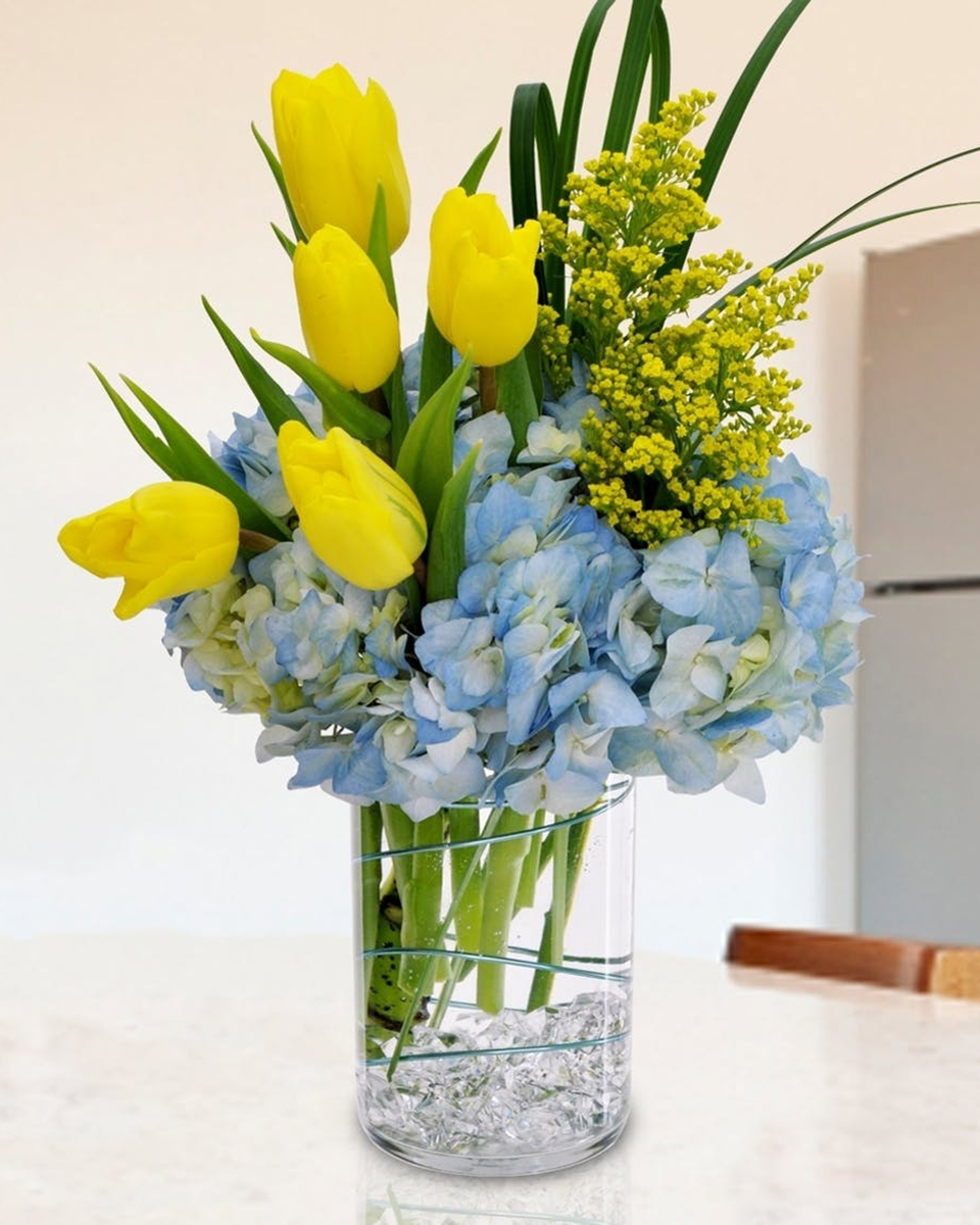 The Bruin The Bruin-Standard Deliver smiles with a bouquet of full-bloom blue hydrangea and fresh Dutch yellow tulips guaranteed to deliver a spring surprise!
DELIVERY: Every order is hand-delivered direct to the recipient. These items will be delivered by us locally, or a qualified retail local florist.