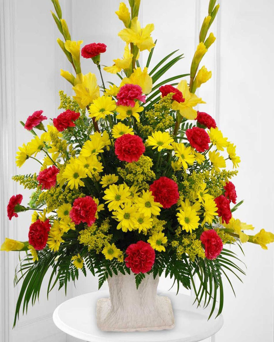 Sincere Tribute Standard Celebrate cherished memories of someone special with this yellow and red funeral floral arrangement featuring daisies, gladiolus, carnations and solidago.
DELIVERY: Every order is hand-delivered direct to the recipient. These items will be delivered by us locally, or a qualified retail local florist.