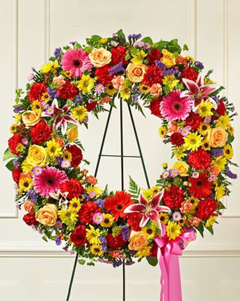 Colores Brilliante Wreath Standard (18 Inch) Beautiful, a standing wreath offers comfort and tribute at a difficult time. Featuring a brilliant mix of bright roses, lilies, gerbera daisies and much more.*DELIVERY: Every order is hand-delivered direct to the recipient. These items will be delivered by us locally, or a qualified retail local florist.
