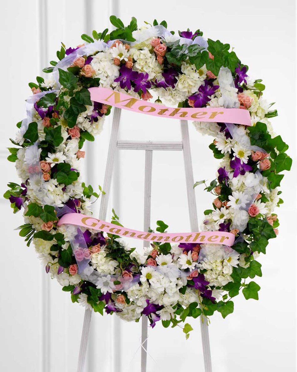 Gentle Woman Deluxe (24 Inch) With this delicate wreath, remember the wonderful woman who graced your life. Honor her memory by displaying this spray featuring shades of white, purple, and pink.
DELIVERY: Every order is hand-delivered direct to the recipient. These items will be delivered by us locally, or a qualified retail local florist.