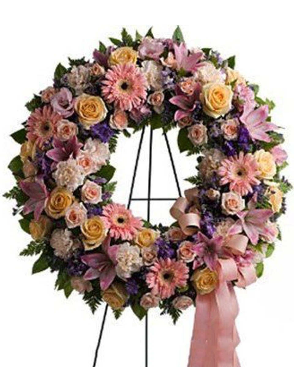 Graceful Wreath Deluxe (24 Inch) A graceful, feminine wreath created with a range of beautiful blossoms in peach, pink, crème and lavender is a lovely depiction of your warm feelings and devotion. Delivered on an easel, for display at a funeral service or wake.
DELIVERY: Every order is hand-delivered direct to the recipient. These items will be delivered by us locally, or a qualified retail local florist.