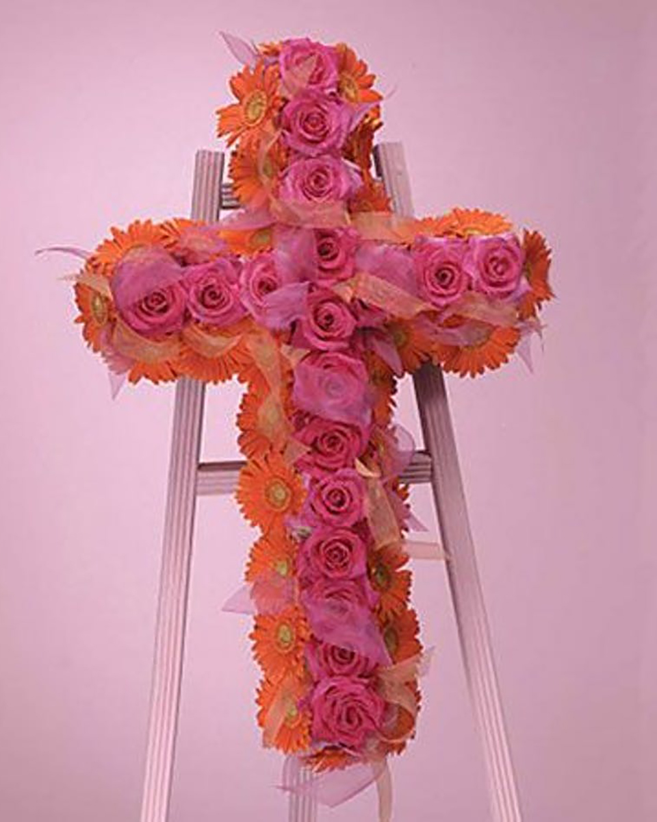 Gerbera and Rose Cross Premium (36 Inch) A stunning and dramatic design of favorite gerbera daisies framing pink garden roses and accented with sheer ribbons. Delivered on a deluxe easle.
DELIVERY: Every order is hand-delivered direct to the recipient. These items will be delivered by us locally, or a qualified retail local florist.