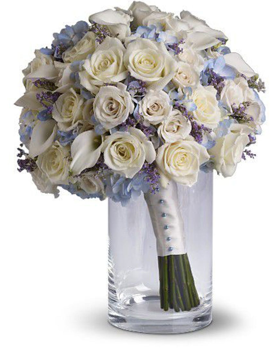 Forever White Roses Standard White Roses, White Mini Calla Lillies, Blue Hydrangea, and Wax Flower are made into a Bridal Bouquet. the stem are Wrapped in White Ribbon with Pearl decorations.
DELIVERY: Every order is hand-delivered direct to the recipient. These items will be delivered by us locally, or a qualified retail local florist.