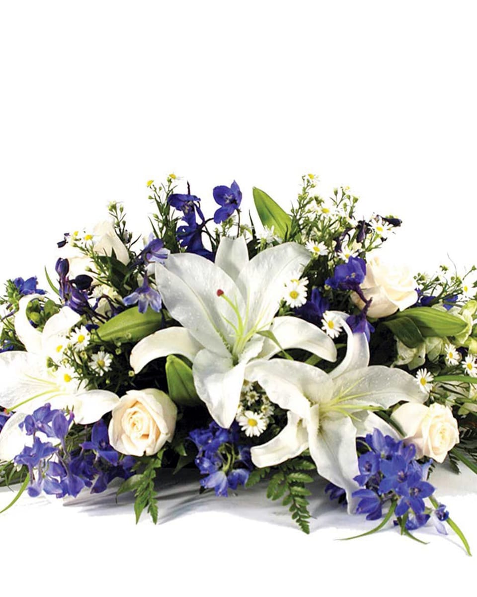 Blue Mountain Standard White Casa Blanca Lilies, White Roses, White Monte Casino, Blue Bella Donna Delphinium, and assorted greens comprise this Hanukah Centerpiece DELIVERY: Every order is hand-delivered direct to the recipient. These items will be delivered by us locally, or a qualified retail local florist.