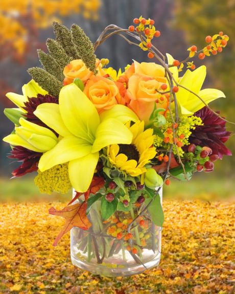 Fall fandago-Yellow Asiatic Lillies, Yellow Roses, Sunflowers, Hypericom, Bittersweet, Millet, Pom Pons, and Fall Foliage are arranged in a vase.-Fall Arrangement