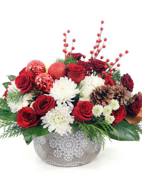 MERRY AND BRIGHT-Bright red roses, deep red spray roses, fluffy white hydrangea, and more are designed with holiday greens and trimmings, including pine cones, ornaments, and ilex berries.-XMAS FLOWERS