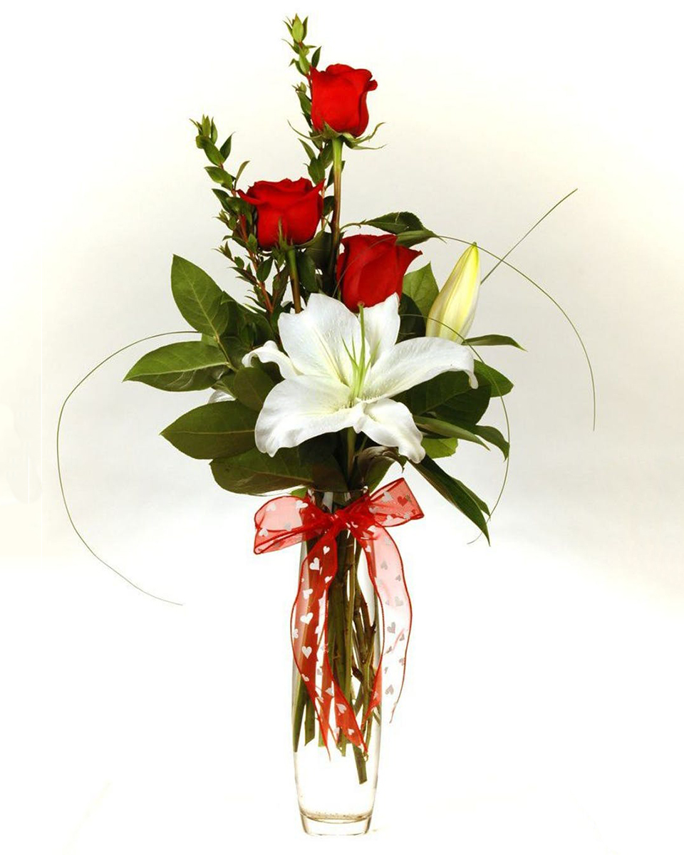 Roseland Roseland 3 Red Roses, A white or pink oriental lilly, and assorted greens are designed in a glass vase that is accentuated with a red bow.
DELIVERY: Every order is hand-delivered direct to the recipient. These items will be delivered by us locally, or a qualified retail local florist.